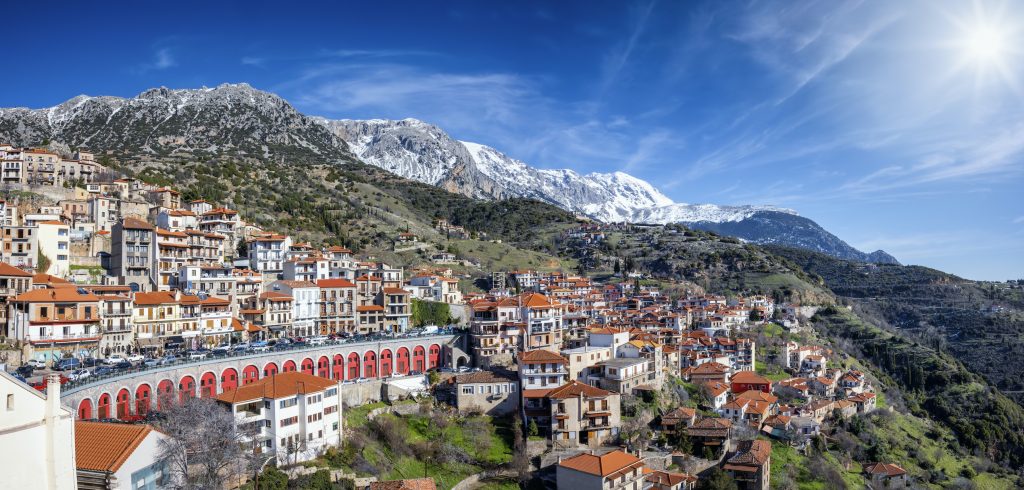 Panorama of the town Arachova, Greece, next to Parnassus mountain during a sunny winter day with snow capped mountains and sunshine